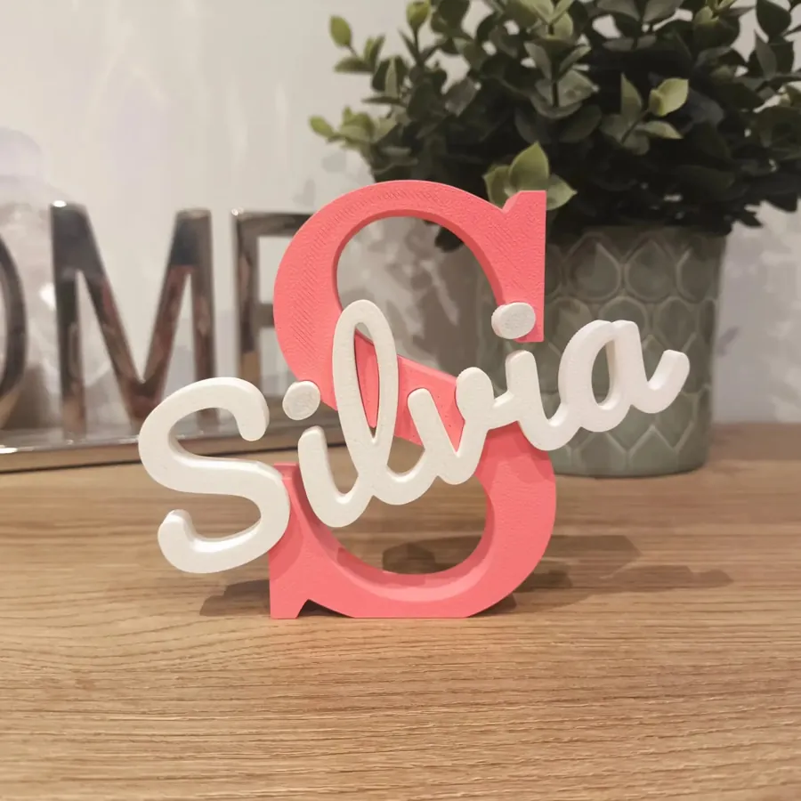 Letra S coral con el nombre Silvia sobre una mesa de madera